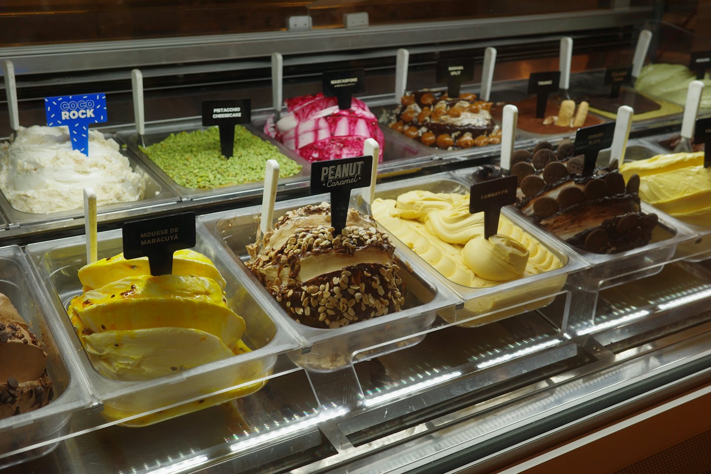 Glass display case filled with rows of colorful artisanal gelato.